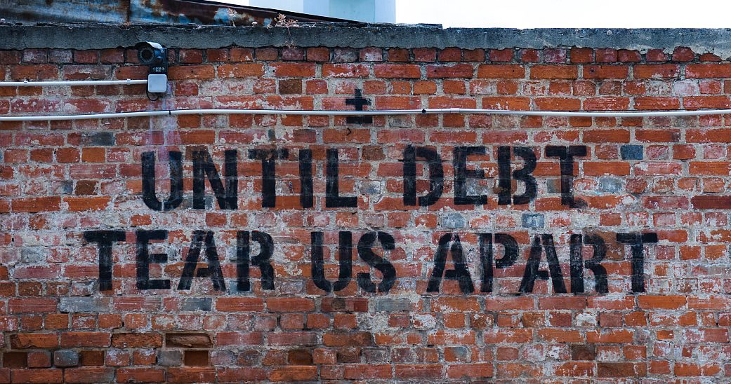 sign saying 'Until debt tear us apart' representing debt recovery against companies