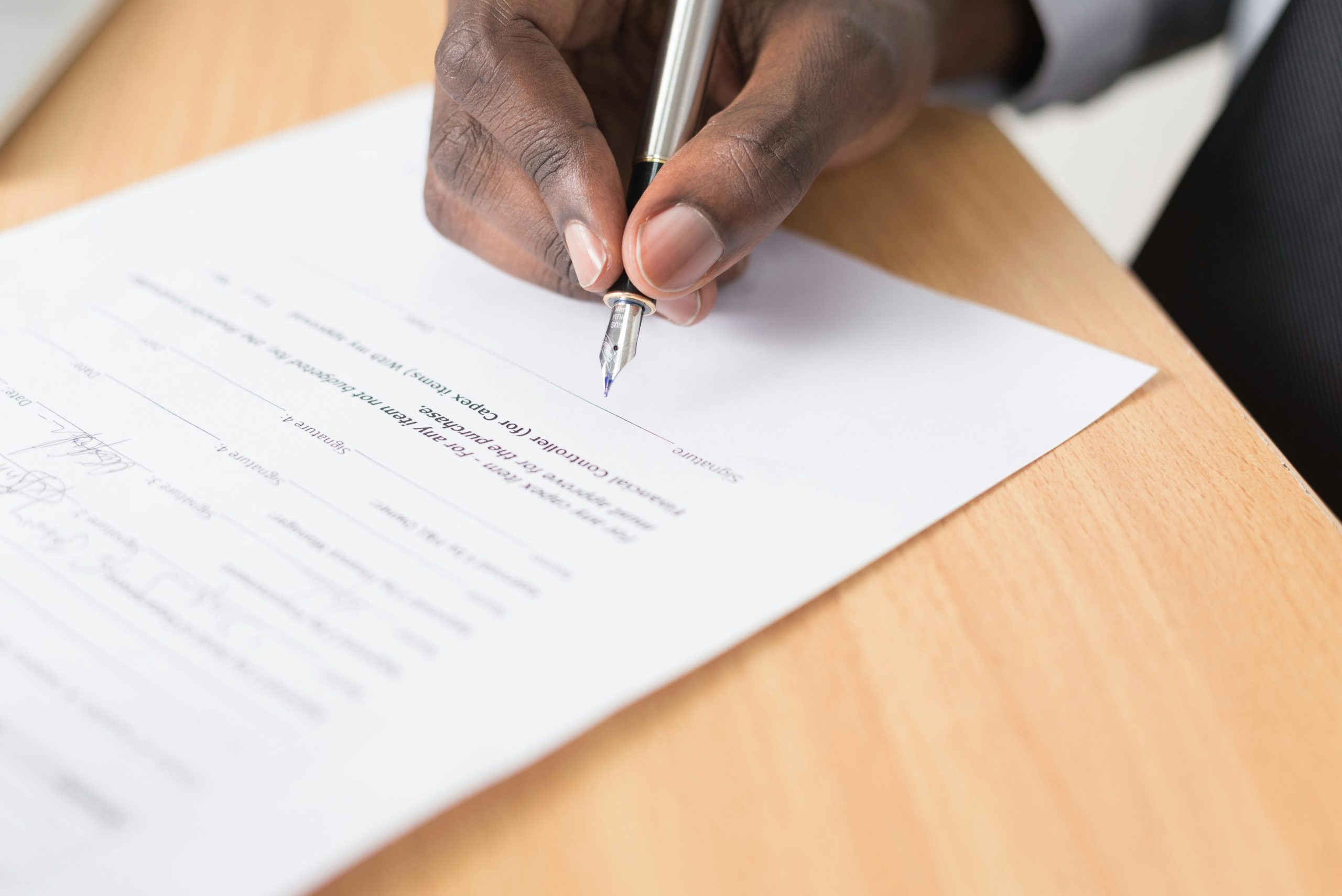 image of someone signing a legal document illustrating the setting up of a trust deed